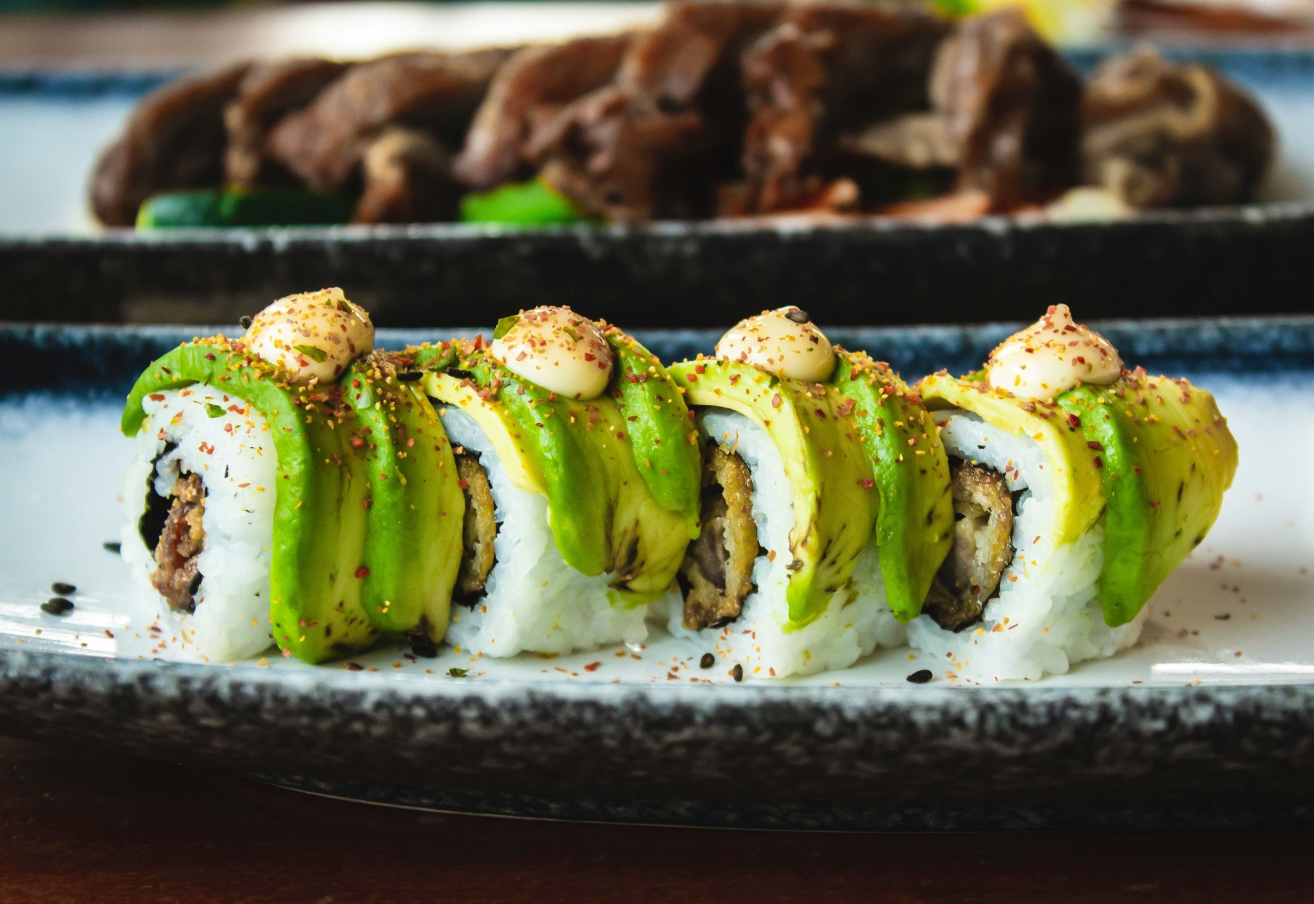 sushi-con-aguacate-sobre-plato-y-mesa-de-madera